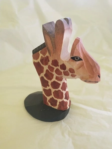 Hand-carved wooden giraffe head eyeglass holder with brown spotted patterns and black base