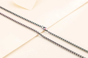 Macro view of a rainbow plated stainless steel box chain necklace with lobster clasp