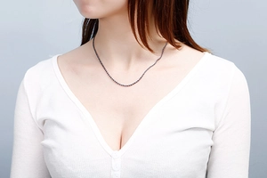 Close-up of a twisted stainless steel rope chain necklace worn on a model's neck