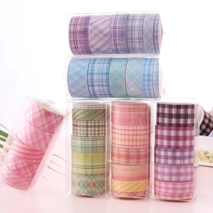 Set of colorful grid pattern washi tape rolls in transparent creative stationery boxes