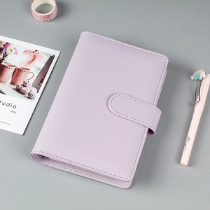 Detail of lavender PU leather notebook with buckle closure and stationery items