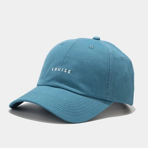 Detail of the white 'CRUISE' embroidery on a blue cotton baseball cap with stitch lines