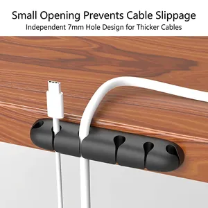 Black silicone desk cable organizer with 5 slots and 7mm wide hole on dark wood desk