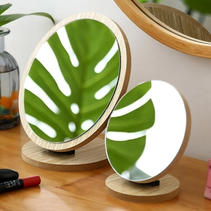 Set of two round desktop makeup mirrors with natural wooden frames and sturdy bases