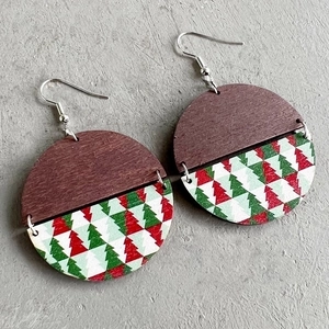 Detailed view of Christmas wooden round earrings with festive red and green tree patterns