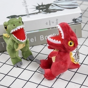 Cute green and red plush Tyrannosaurus Rex dinosaur keychains on a checkered background