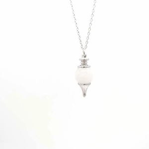 Macro view of crystal pendant necklace with white gemstone and silver-tone setting