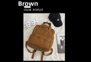 Brown canvas backpack detail featuring the front zipper pocket and minimalist vintage style