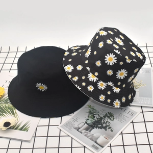 Detail view of cotton bucket hats with daisy prints on a stylish checkered background