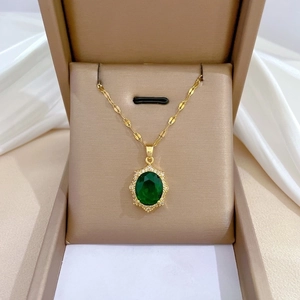 Close-up of a green oval gemstone pendant with diamond halo in a gift box with silk