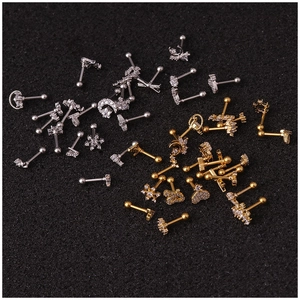 Multiple styles of stainless steel stud earrings in gold and silver on black foam background