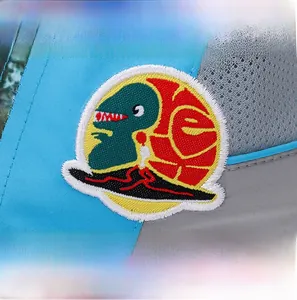 Makrodetail von Cartoon-Dinosaurier-Stickerei und atmungsaktivem Netz an Kinderkappe