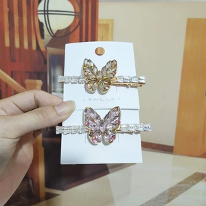 Close-up of champagne and purple crystal butterfly hair clips on a jewelry card