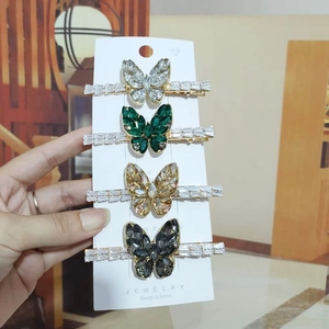 Detailed view of four butterfly hair clips set with sparkling colorful zircons and crystals