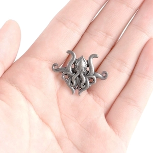 Vintage silver octopus brooch in Cthulhu style made of textured alloy on white background