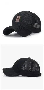 Detailed view of breathable mesh fabric and brown leather label on black baseball cap