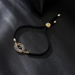 Detail of adjustable evil eye bracelet with colorful zircons on black leather background