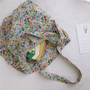 Detail of floral cotton tote bag with mint green background and colorful flower patterns