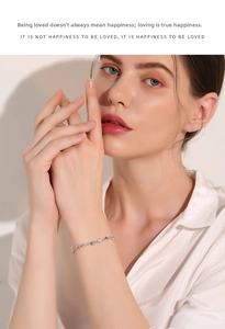 Close-up of 925 sterling silver heart bracelet on wrist with elegant silk shirt