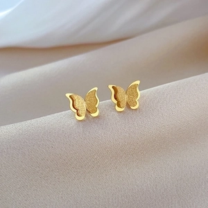 Macro view of butterfly stud earrings featuring double-layered gold foil wings and matte finish