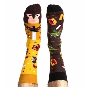 Asymmetric cartoon socks featuring yellow knight and brown dragon motifs on white background