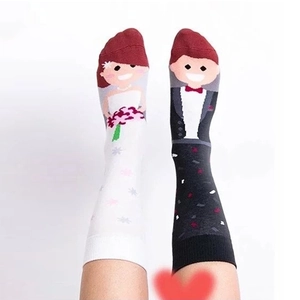 Detailed view of asymmetric wedding socks featuring bride and groom cartoon patterns