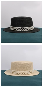 Detail von flachen Strohhüten mit luxuriösen Perlenbändern in Schwarz und Beige Tönen