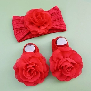 Detail of red baby headband and matching socks with large layered chiffon flowers
