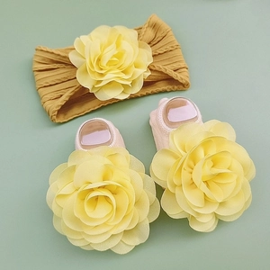 Close-up of baby headband and socks set featuring large chiffon flowers and ribbed fabric