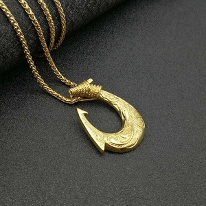 Gold Viking fish hook necklace with engraved patterns on twisted chain, black background