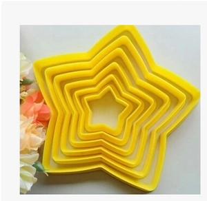 Nesting star-shaped cookie cutters in various sizes made of durable yellow plastic