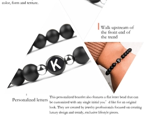 Detail view of 6mm matte black onyx beads with custom silver letter charms for bracelets