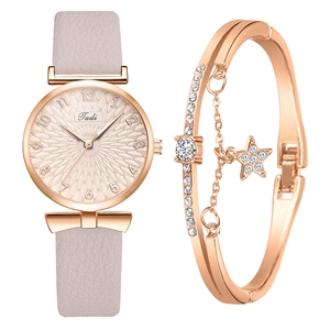 Détail d'une montre femme en or rose avec bracelet en cuir et bracelet jonc étoile brillant