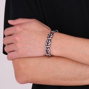 Close-up of a vintage stainless steel knot bracelet worn on a man's wrist