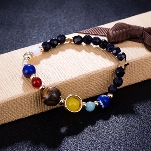 Solar System bracelet with natural stones and gold stars on a beige gift box