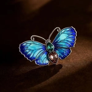 Detailed close-up of a blue enamel butterfly brooch with inlaid sparkling gemstones