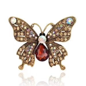 Colorful butterfly brooch with red gemstone and sparkling crystals on gold metal base