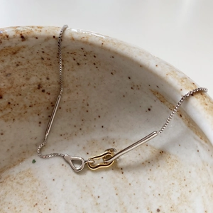 Macro shot of 925 sterling silver box chain necklace with gold and silver interlaced links