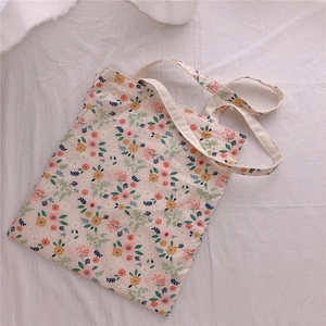 Detailed close-up of floral pattern canvas tote bag with reinforced cream handles