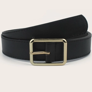 Close-up of black elastic belt with golden rectangular buckle and leather texture