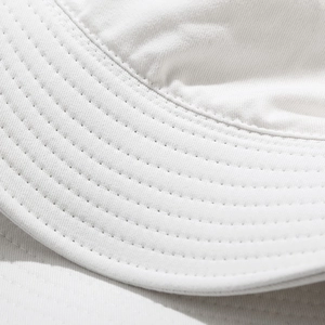 Detailed macro view of parallel stitching and twill cotton fabric on white bucket hat brim