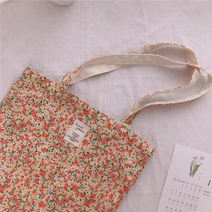 Detail of floral canvas tote bag with vintage pattern and rectangular woven patch