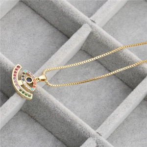 Gold Evil Eye necklace with micro-p鑲 ziconia on a gray velvet jewelry display box