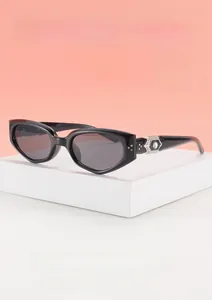 Detail of black frame sunglasses with a silver star and rhinestone temple ornament