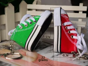 Macro detail of mini canvas shoe keychain with metal ring and dimensions 7.5x4cm