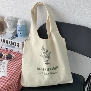 Minimalist canvas tote bag with green plant print and handles for daily shoulder use