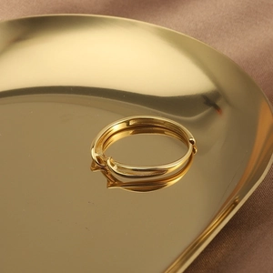 Minimalist s925 silver twisted ring in gold finish on a luxury decorative tray