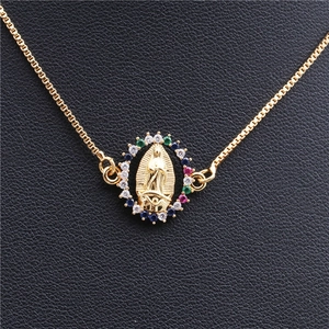 Macro shot of gold bracelet with a religious Virgin Mary charm and colorful zircon stones