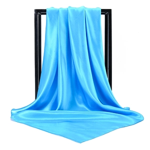 Close-up of bright blue satin silk scarf showing elegant drape and smooth texture