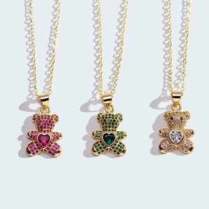 Three gold necklaces featuring micro-pave bear pendants with pink green and white hearts